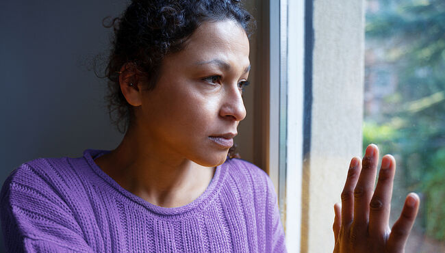 Woman sadly looking out the window.